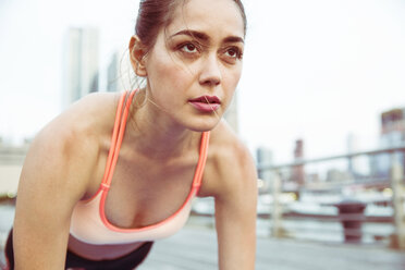 Woman looking away while exercising on bridge - CAVF45413