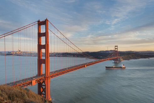 USA, Kalifornien, San Francisco, Schiff überquert Golden Gate Bridge am Abend - MKFF00362