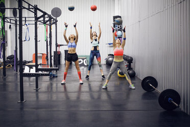 Female athletes exercising with medicine balls at gym - CAVF45491