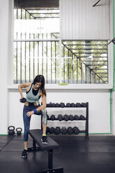 Determined female athlete lifting dumbbell at gym - CAVF45526