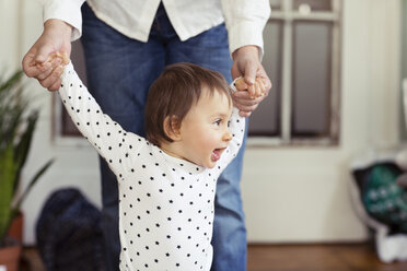 Midsection of woman holding granddaughter's hands at home - CAVF45558