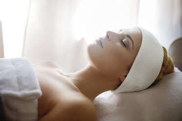 Relaxed woman lying on massage table in spa - CAVF45571