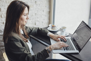 Seitenansicht einer Geschäftsfrau mit Laptop im Restaurant - CAVF45612