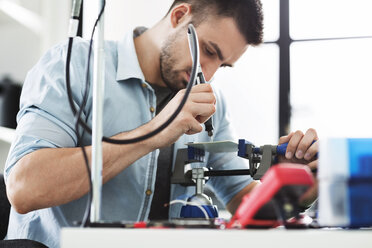 Nahaufnahme eines Ingenieurs beim Löten einer Leiterplatte im Elektroniklabor - CAVF45680