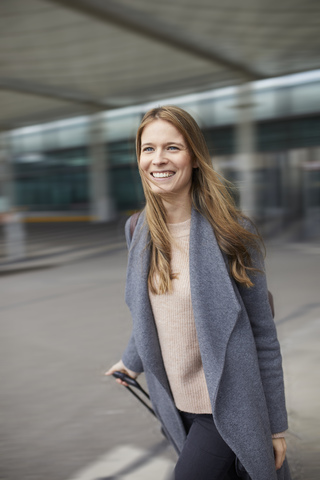 Portrait of confident businesswoman pulling suitcase at airport stock photo