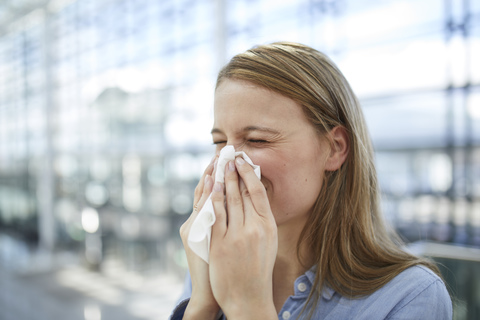 Young woman blowing nose stock photo