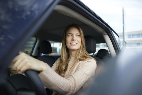 Porträt einer lächelnden jungen Frau, die im Auto sitzt - PNEF00615