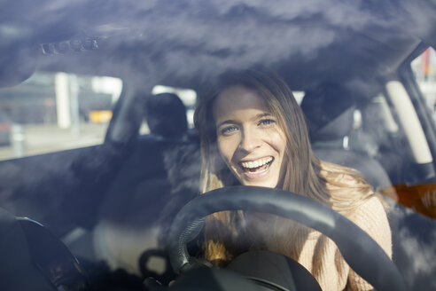 Portrait of laughing young woman in car - PNEF00616