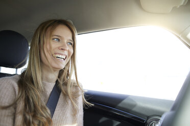Porträt einer lachenden jungen Frau im Auto - PNEF00618