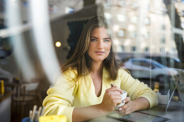 Porträt einer lächelnden jungen Frau in einem Cafe - DIGF03917