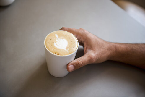 Hand und Tasse Cappuccino in einem Cafe - DIGF03926