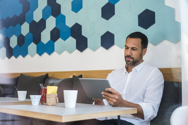 Mann benutzt Tablet in einem Café - DIGF03931