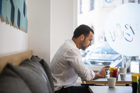 Man using tablet in a cafe stock photo