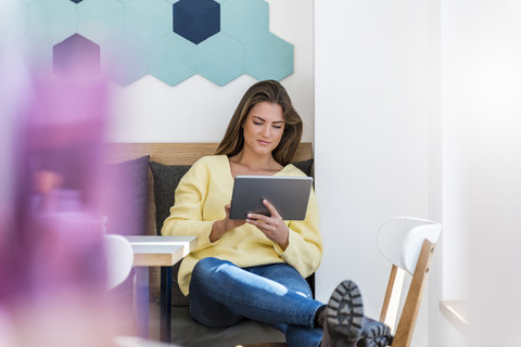 Entspannte junge Frau mit Tablet in einem Café, lizenzfreies Stockfoto