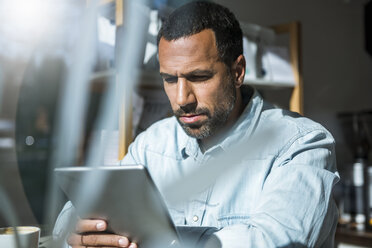 Man using tablet in a cafe - DIGF03942