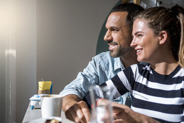 Happy couple in a cafe looking out of window - DIGF03945