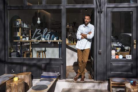 Man standing at entrance door of a cafe stock photo
