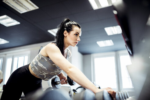 Frau beim Training mit Hanteln im Fitnessstudio - DAWF00614