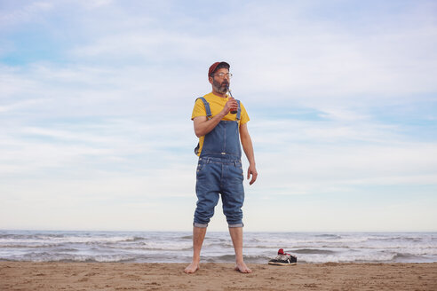 Bärtiger Mann trinkt Softdrink am Strand - RTBF01184