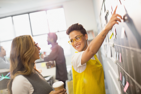 Creative businesswomen planning, scheduling at calendar blackboard stock photo