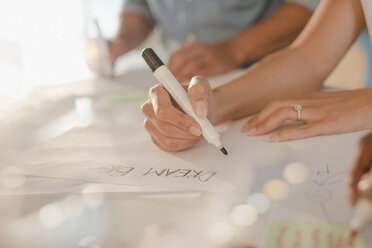 Creative female entrepreneur writing “Dream Big” on poster - HOXF03392