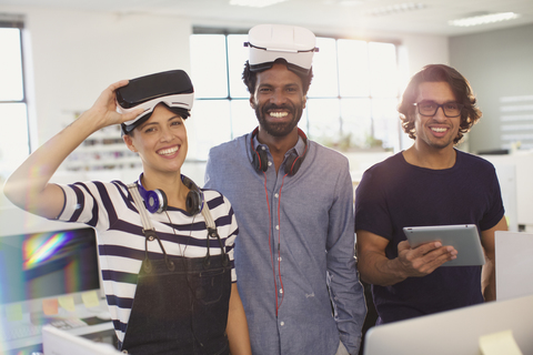 Porträt lächelnder, selbstbewusster Computerprogrammierer beim Testen von Virtual-Reality-Simulatoren im Büro, lizenzfreies Stockfoto