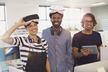 Porträt lächelnder, selbstbewusster Computerprogrammierer beim Testen von Virtual-Reality-Simulatoren im Büro - HOXF03402