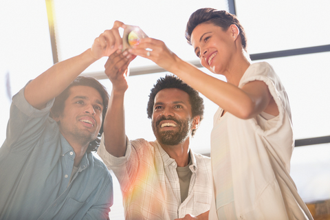 Smiling, innovative entrepreneurs examining prototype stock photo