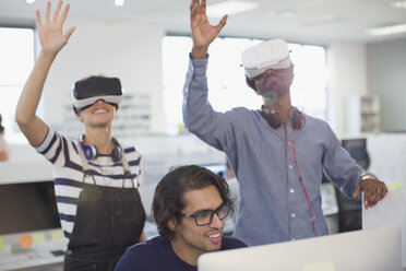 Computer programmers testing virtual reality simulators in office - HOXF03458