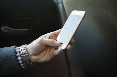 Cropped image of man using mobile phone while traveling in car - CAVF45712