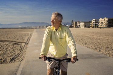 Mann mit Fahrrad auf der Straße stehend gegen blauen Himmel - CAVF45758
