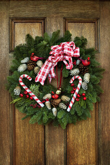 Christmas wreath hanging on wooden door - CAVF45769