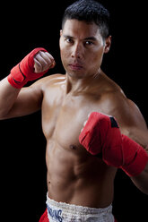 Portrait of shirtless confident boxer against black background - CAVF45815