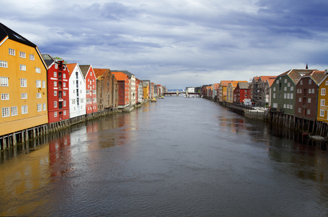 Der Fluss Nidelva inmitten von Häusern bei bewölktem Himmel, lizenzfreies Stockfoto