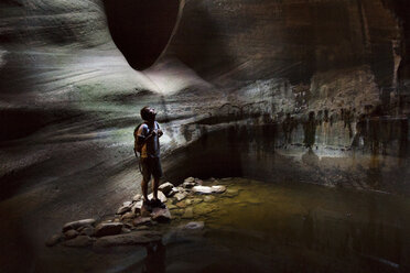 Wanderer, der in der Höhle steht und nach oben schaut - CAVF45830