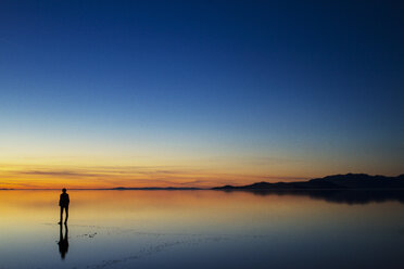 Silhouette Frau am Strand bei Sonnenuntergang stehend - CAVF45867