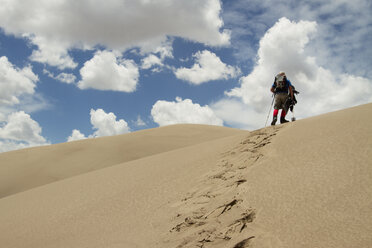 Low angle view of hiker walking in desert - CAVF45873