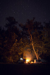 Lagerfeuer auf einem Feld im Wald bei Nacht - CAVF45885