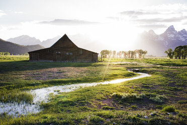 Blockhaus auf einem Feld gegen die Berge an einem sonnigen Tag - CAVF45903