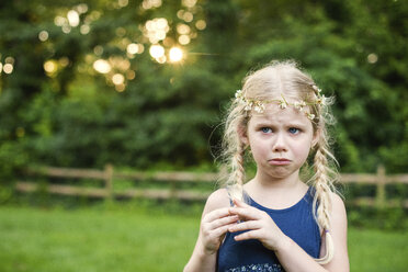 Sad girl looking away while standing in backyard - CAVF45926