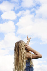 Side view of girl pointing towards sky - CAVF45935