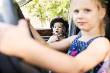 Porträt eines süßen Jungen, der mit seiner Schwester im Auto sitzt - CAVF46002