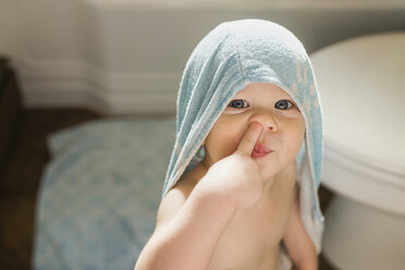 Portrait of cute boy with finger in nose at home - CAVF46005