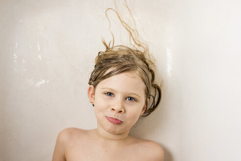 Porträt eines Oben-ohne-Mädchens, das in einer Badewanne im Badezimmer zu Hause liegt - CAVF46022
