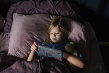 Hohe Winkel Ansicht von Mädchen mit Tablet-Computer, während auf dem Bett liegend zu Hause - CAVF46023
