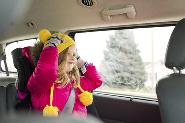 Glückliches Mädchen in warmer Kleidung auf Reisen im Auto - CAVF46051