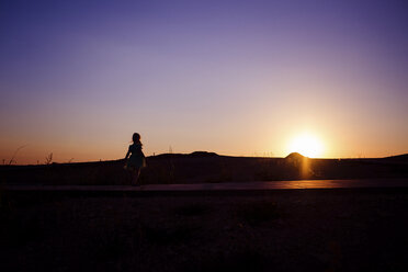 Silhouette Mädchen steht im Park gegen den Himmel bei Sonnenuntergang - CAVF46060