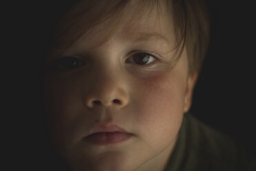 Close-up portrait of cute boy in dark room - CAVF46089