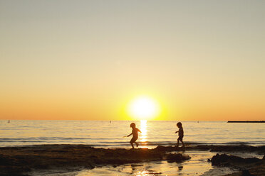 Silhouette Geschwister zu Fuß am Strand gegen klaren Himmel bei Sonnenuntergang - CAVF46093