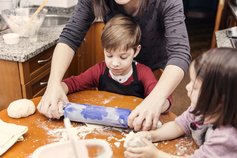 Mutter und Kinder kochen gemeinsam in der Küche, lizenzfreies Stockfoto